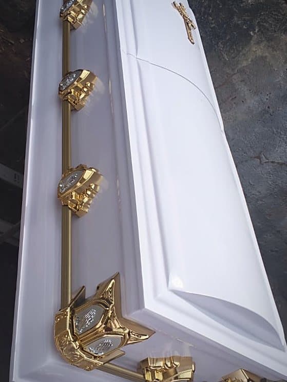 Gilt Lord's Supper handles running the length of a white dome-lid casket