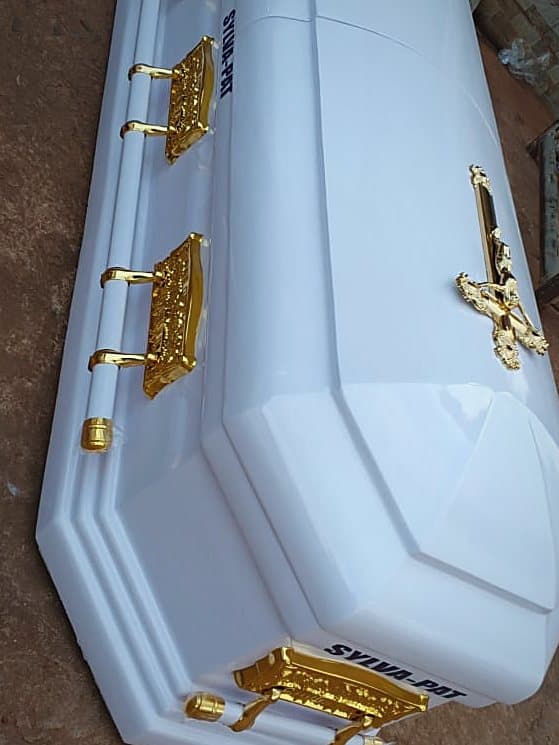 A pale dome-lid casket with gilt bar handles and a gilt crucifix