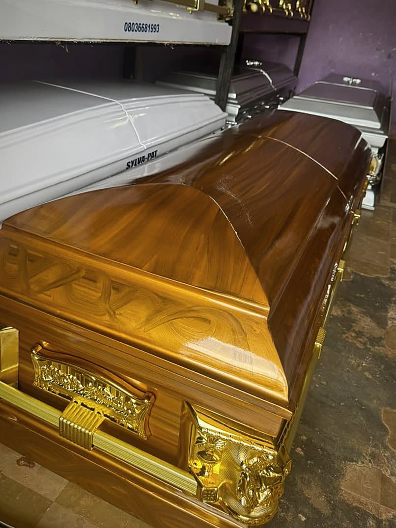 A figured golden-timber Supreme casket with heavy gilt bar handles