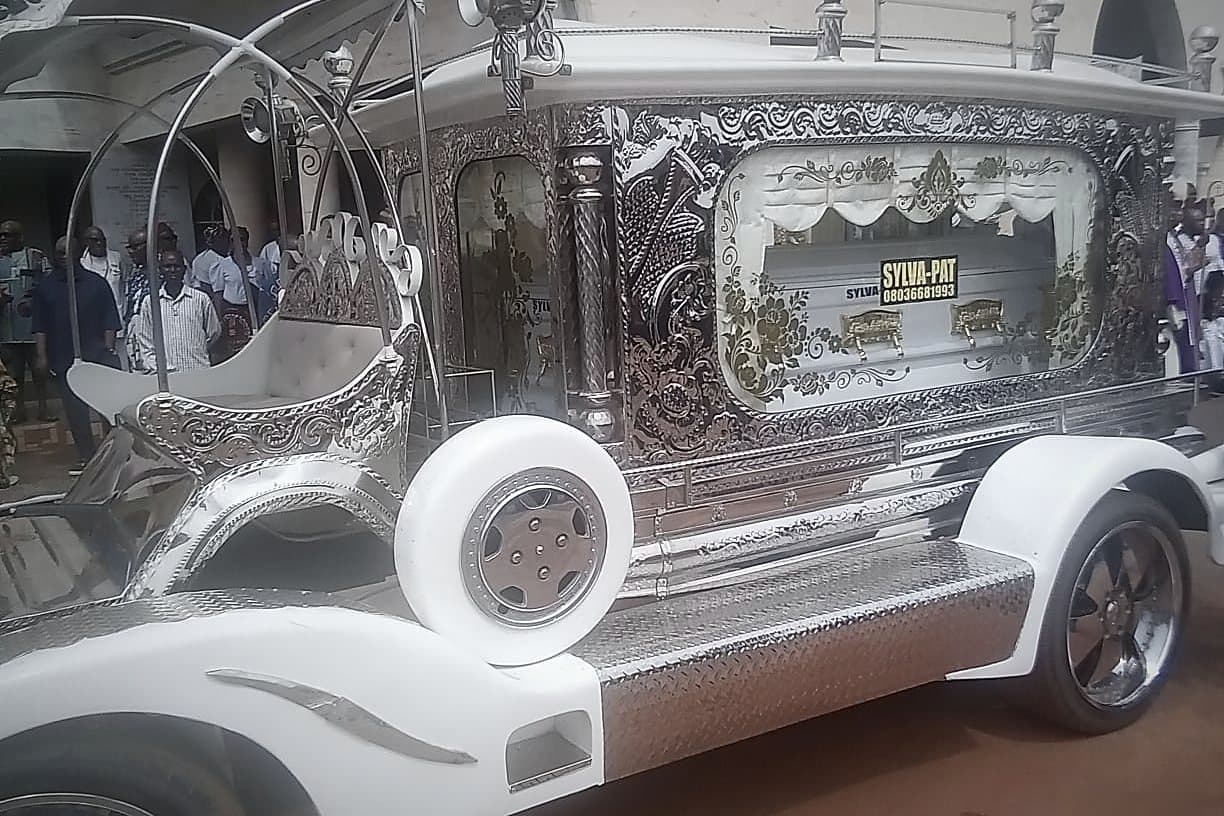 The ornate silver carriage hearse, embossed panels and a spare wheel on the flank