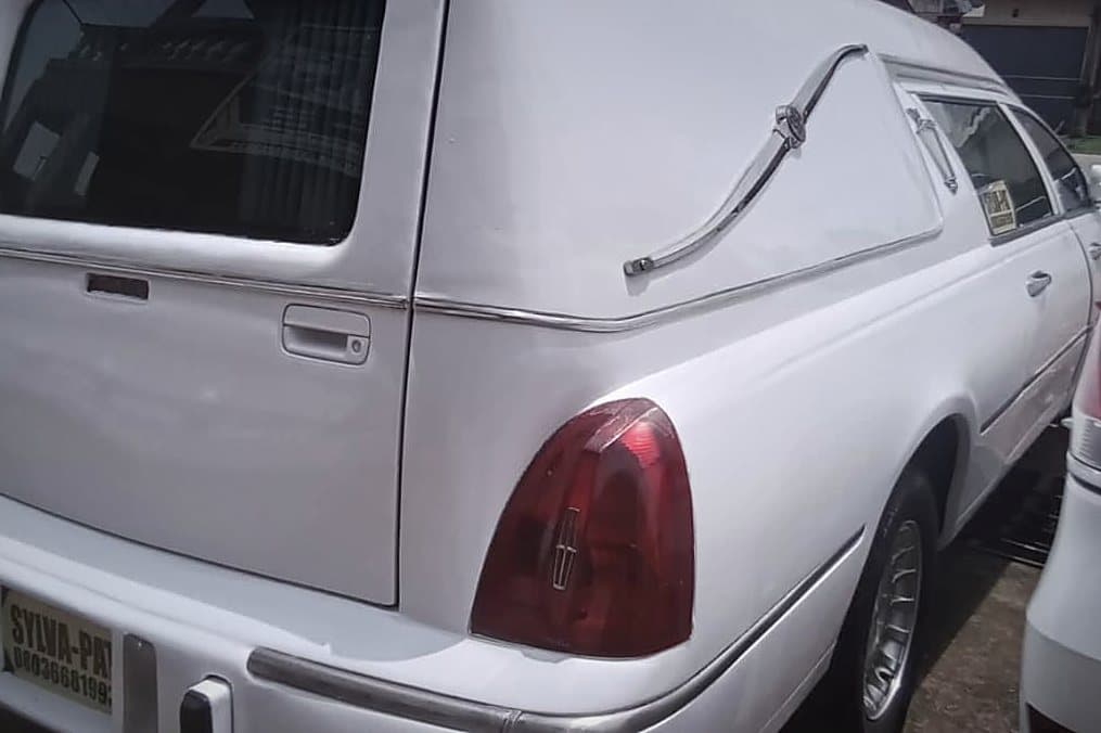 The white Lincoln hearse photographed from behind, showing the raised coach roof