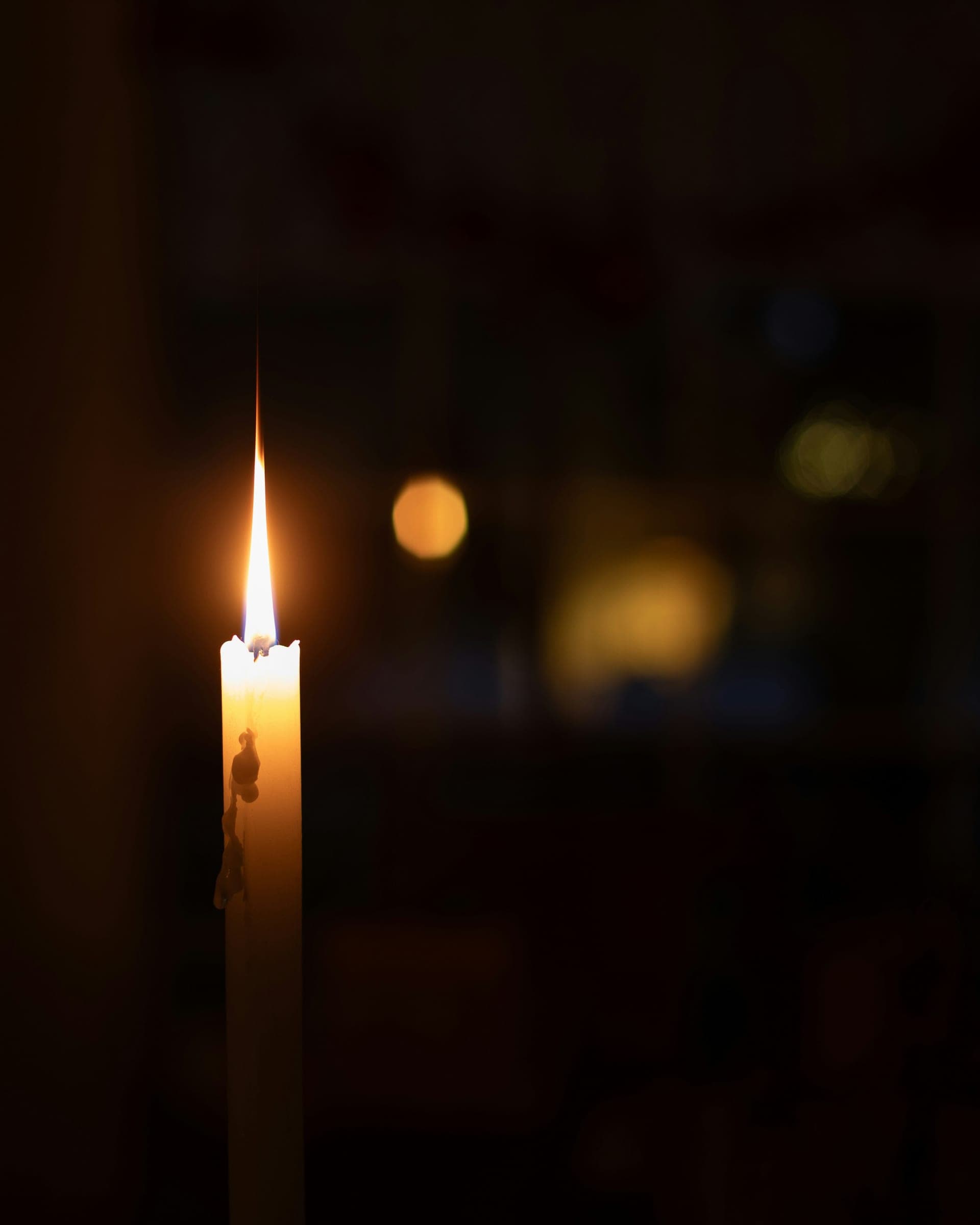 A single candle burning in a darkened room